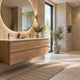 Ruime moderne badkamer met houten badkamermeubel, dubbele wastafel, ronde spiegel en beige tegels