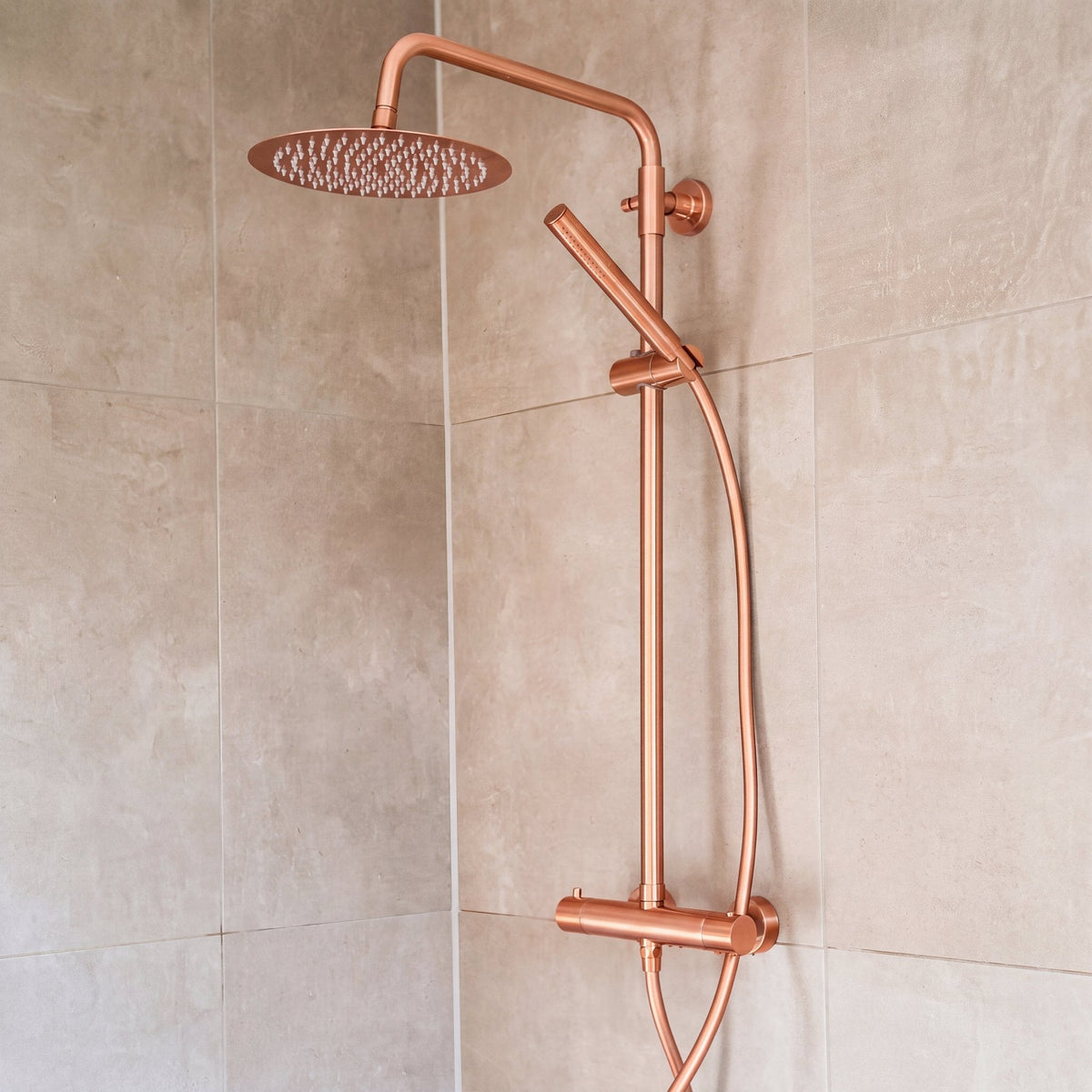 Ronde regendoucheset Novi in rosé koper gemonteerd in een douche