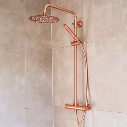 Ronde regendoucheset Novi in rosé koper gemonteerd in een douche