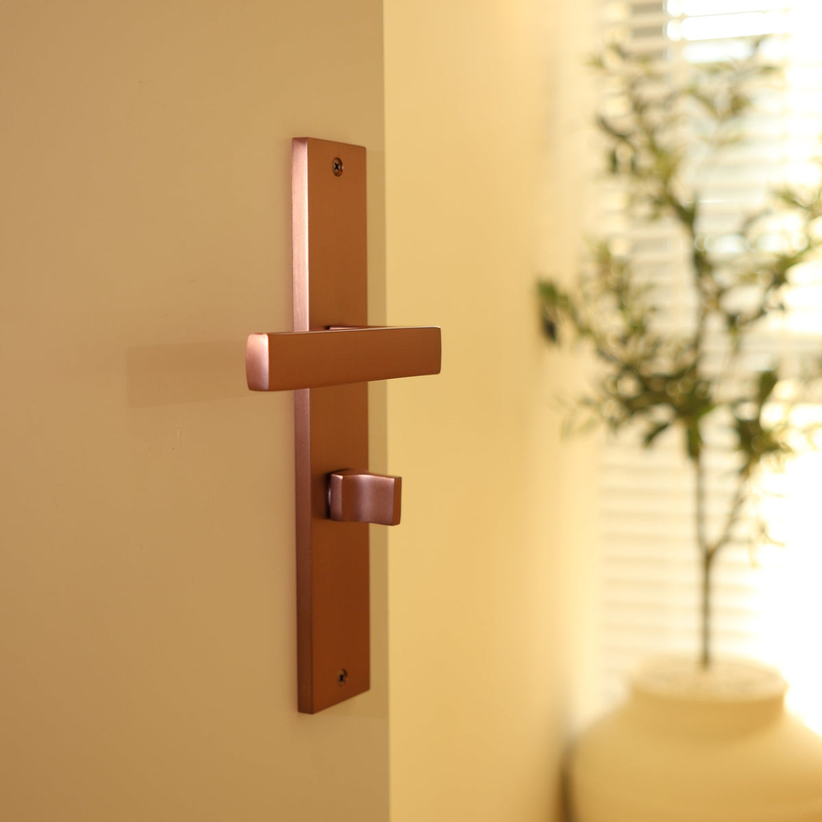 Deurklink Collodi in koper met WC-sluiting 63 mm gemonteerd op een deur