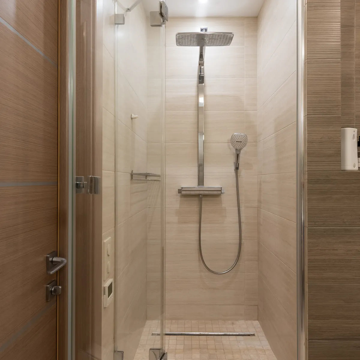 Beige wandtegels 30x90 cm horizontaal verwerkt in een moderne douche