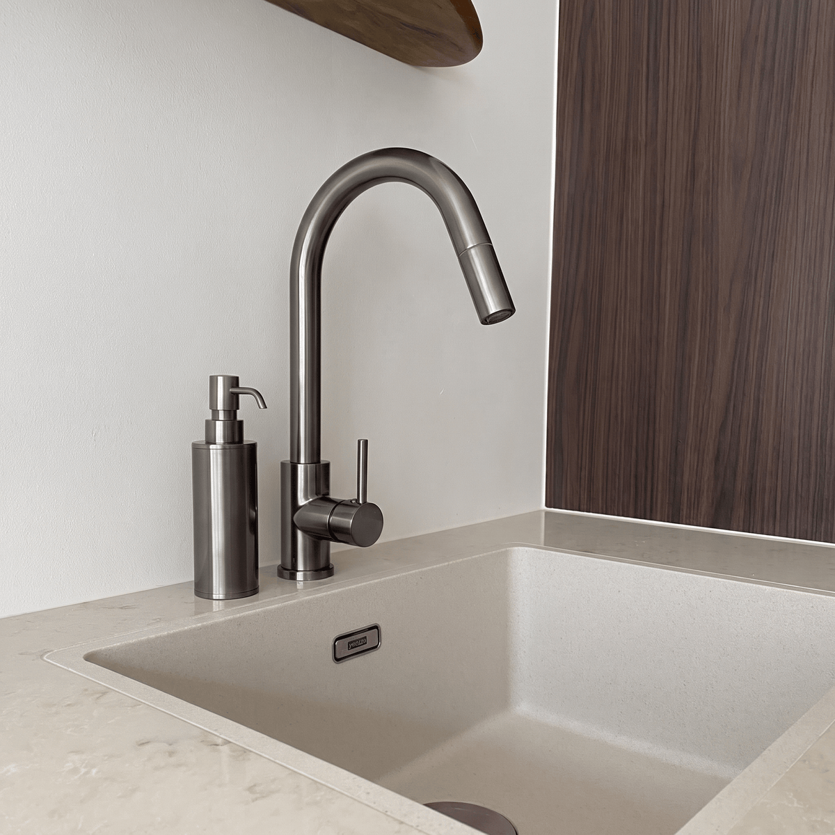 Zeepdispenser Saponi in gun metal naast een spoelbak